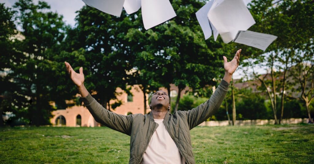 A young man throwing papers into the air in a park, attracting leads and potential customers.