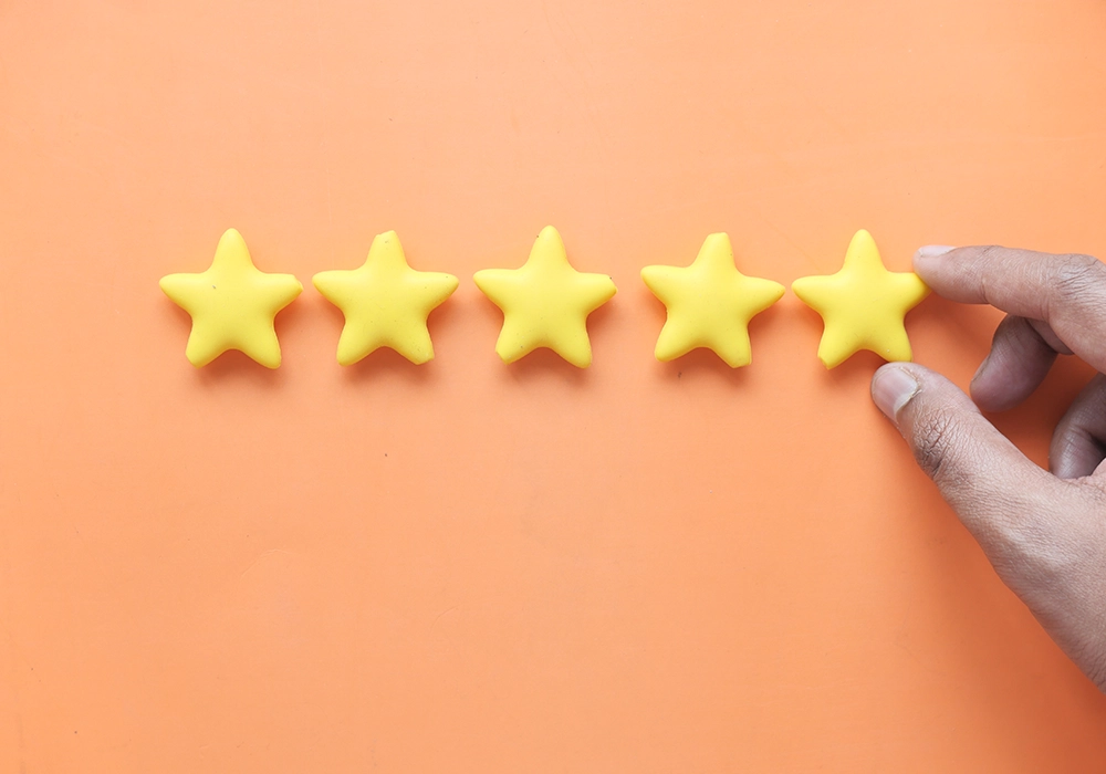 A hand is holding a yellow star on an orange background, providing a visual example of social proof.