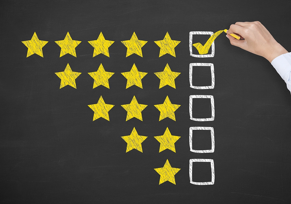 A person utilizing the Power of Social Proof by drawing a star rating on a blackboard.