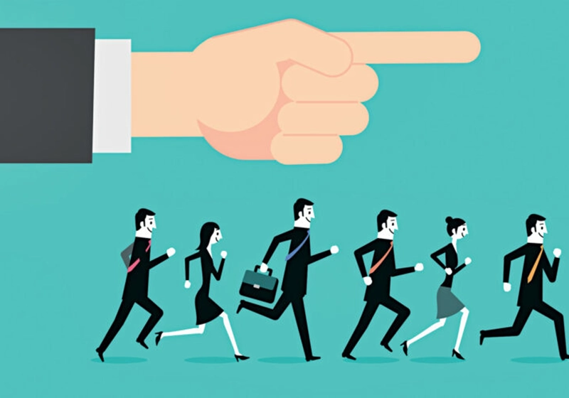 A group of business people running in front of a pointing finger, exemplifying social proof bias.