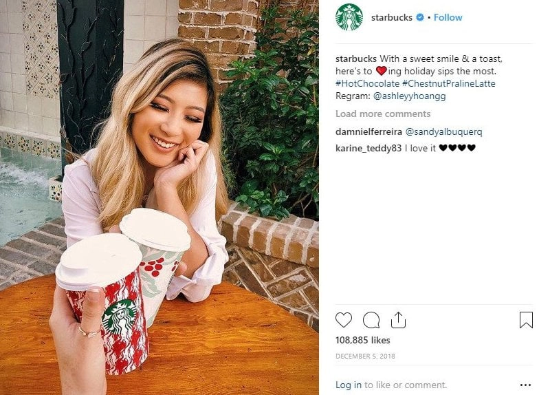 A woman is holding a cup of Starbucks coffee as a social proof example.