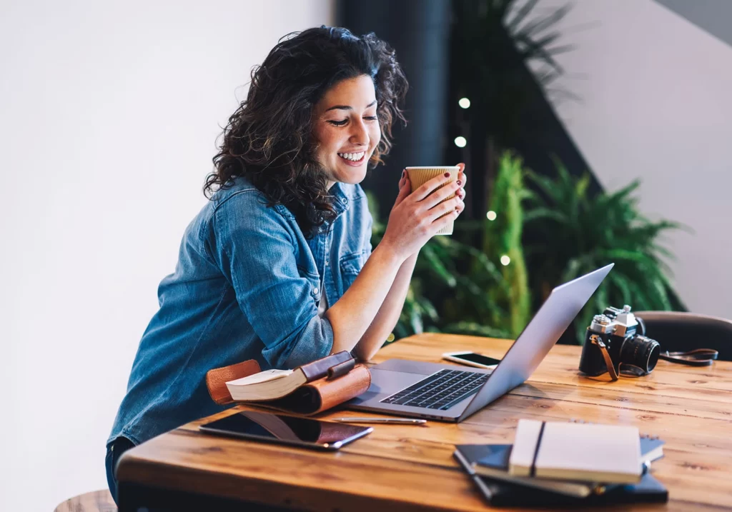 A woman sitting at a desk with a laptop, demonstrating website credibility.