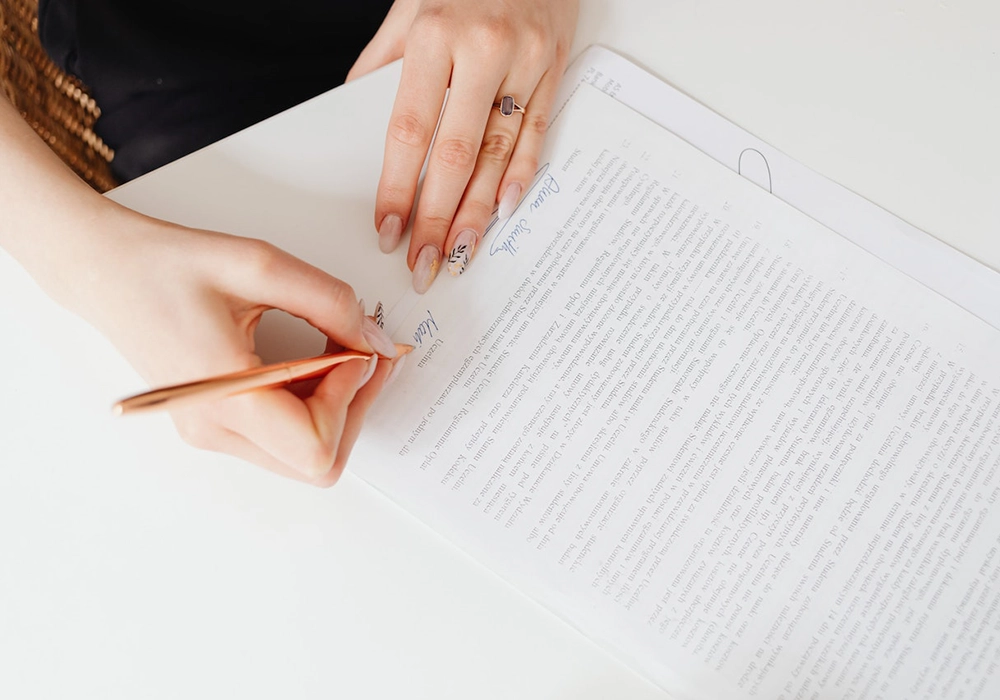 A woman signing a privacy policy document with a pen.