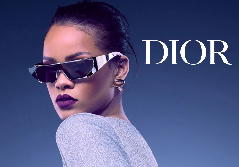 Rihanna wearing stylish Dior sunglasses, which are part of the most successful celebrity endorsement campaign, with the Dior logo prominently displayed. She has sleek hair and a serious expression.