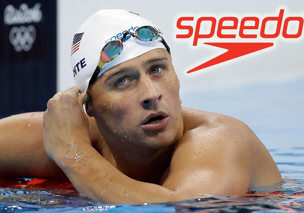 Ryan Swimmers is wearing a white cap and goggles in a pool, with a visible Speedo logo in the background, illustrating one of the celebrity endorsements gone wrong.
