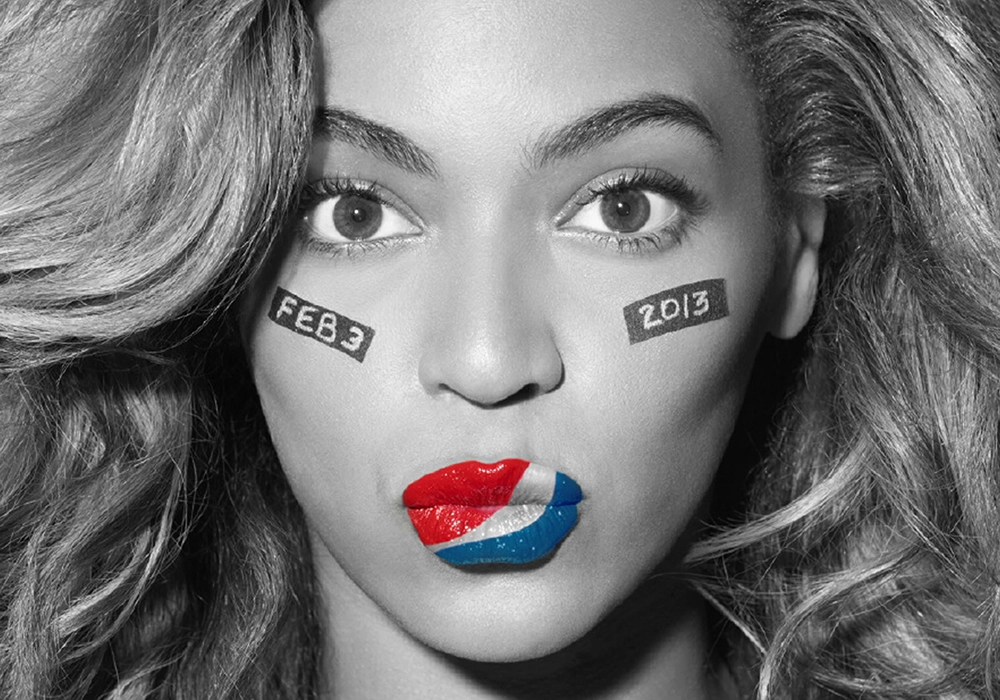 Beyonce with long hair and a serious expression has face paint with the date "FEB 3 2013" on her cheeks. Her lips are painted in red, white, and blue, resembling the Pepsi logo, hinting at celebrity food endorsements.