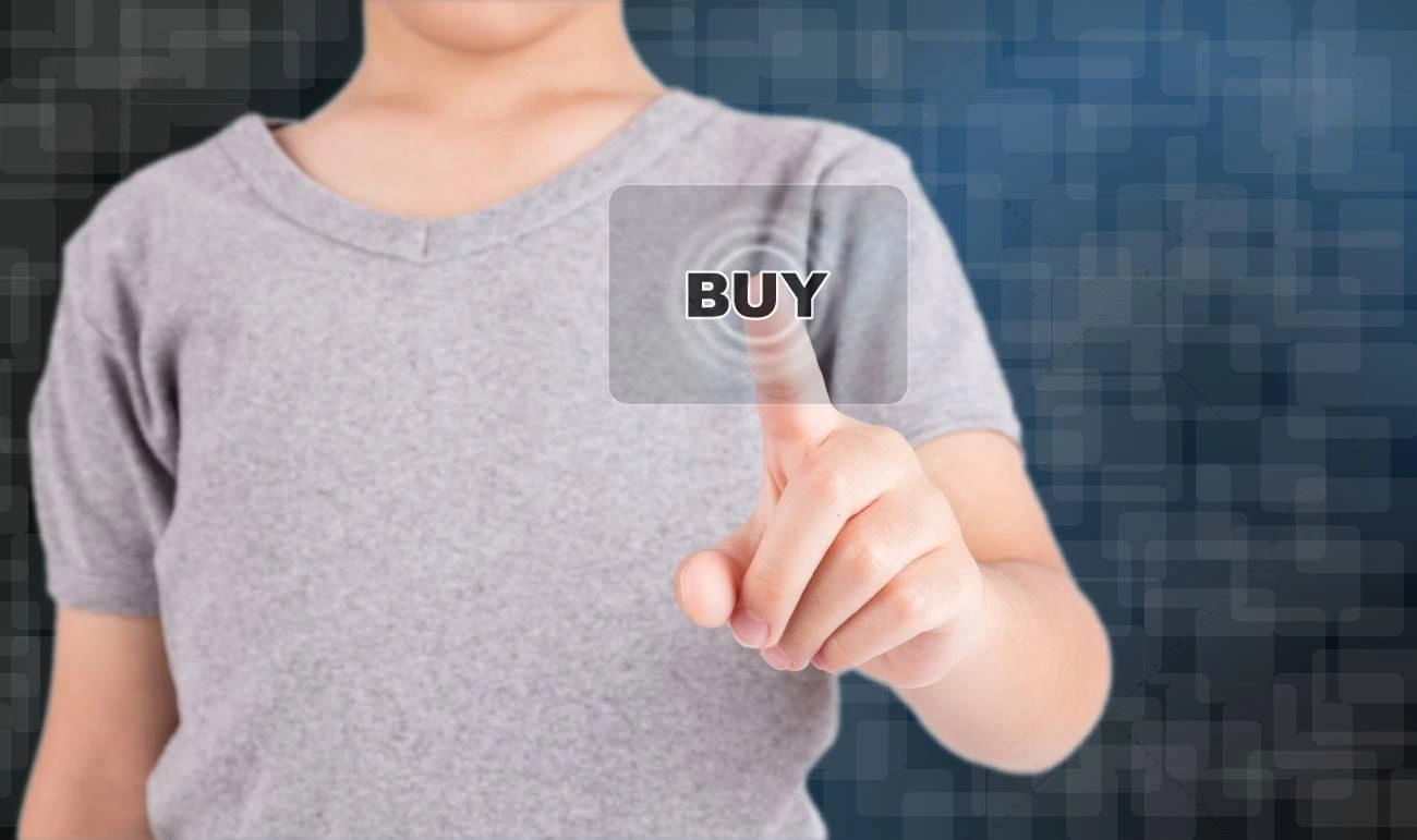 A person in a gray shirt touches a transparent virtual "BUY" button against a digital blue background, illustrating the power of FOMO Marketing in driving instant purchasing decisions.