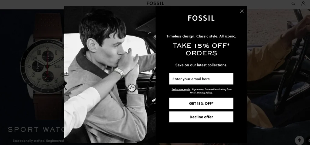 A splash page on the Fossil website offers 15% off orders for signing up with an email, partially obscuring a photo of a man wearing a watch and kissing a woman's hand.